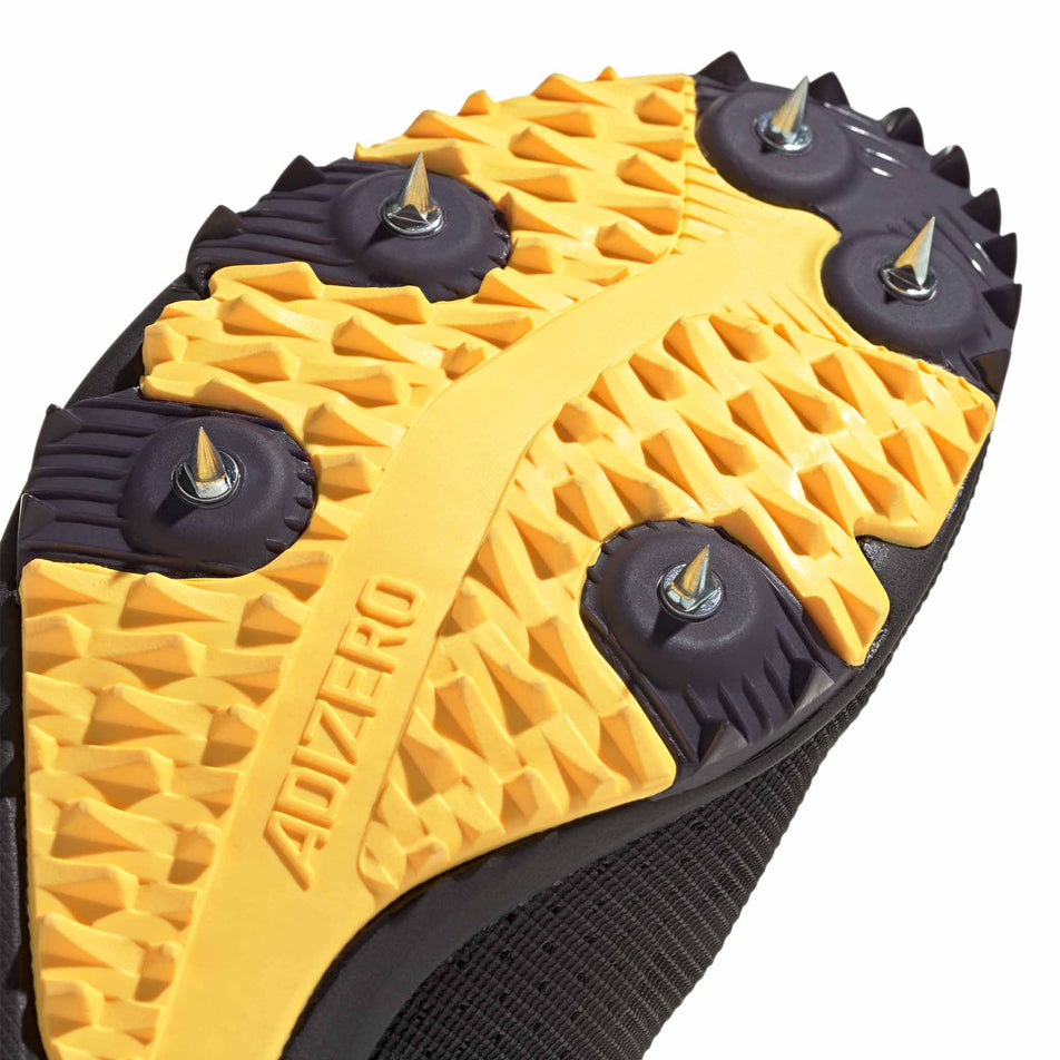 The spikeplate on the forefoot of the right shoe from a pair of adidas Unisex adizero XCS Running Spikes in the core black/zero met./spark colourway. (8472647532706)
