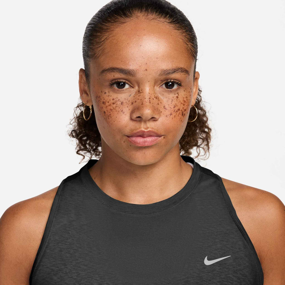 Front view of a model wearing the Nike Women's Swift Breathe Dri-FIT Running Tank Top in the Black/Black/White/Reflective Silver colourway.