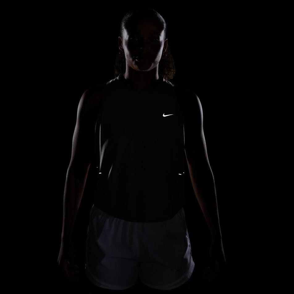 The reflective swoosh on the front of the Nike Women's Swift Breathe Dri-FIT Running Tank Top in the Black/Black/White/Reflective Silver colourway.