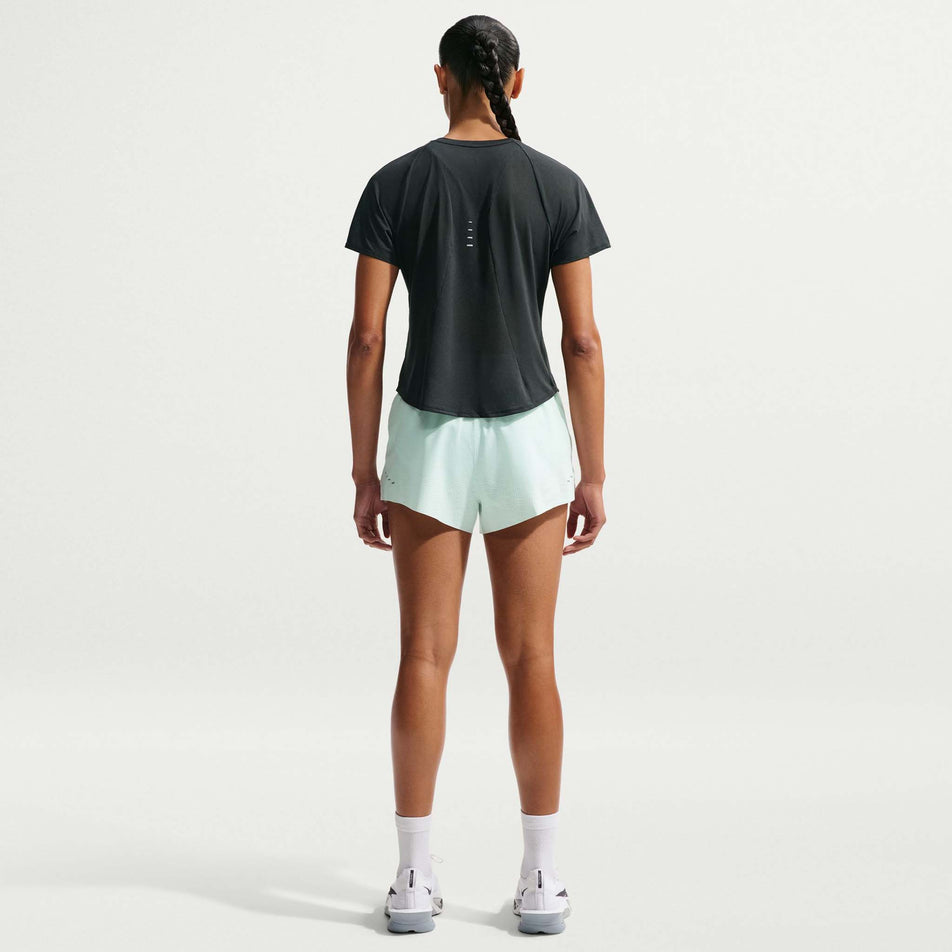 Back view of a model wearing the Nike Women's Swift Breathe Dri-FIT Short-Sleeve Running Top in the Black/Photon Dust/White/Reflective Silver colourway.