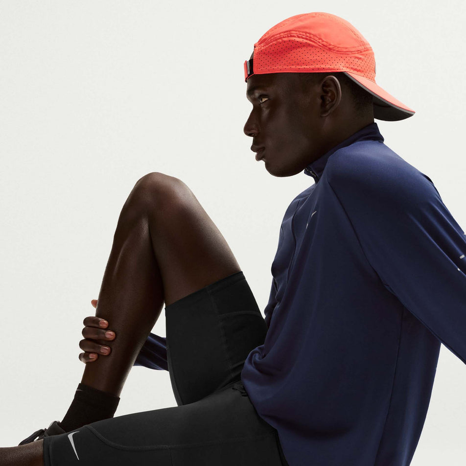 Angled view of a model wearing the Nike Men's Stride Dri-FIT 1/2-Length Running Tights in the Black/Reflective Silver colourway.