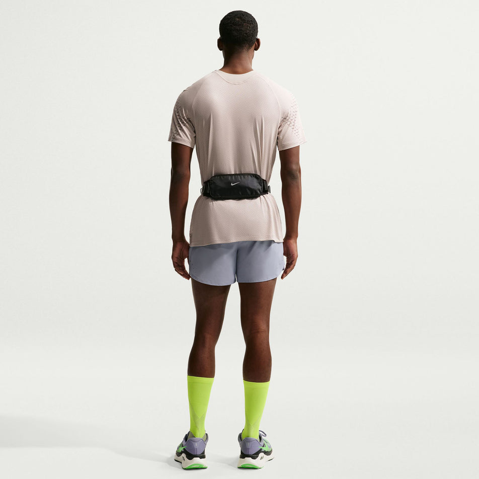 Back view of a model wearing the Nike Men's Stride Dri-FIT ADV Short-Sleeve Running Top in the Cream II/Mink Brown/Reflective Silver colourway.