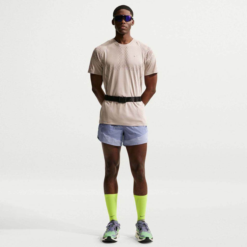 Front view of a model wearing the Nike Men's Stride Dri-FIT ADV Short-Sleeve Running Top in the Cream II/Mink Brown/Reflective Silver colourway.