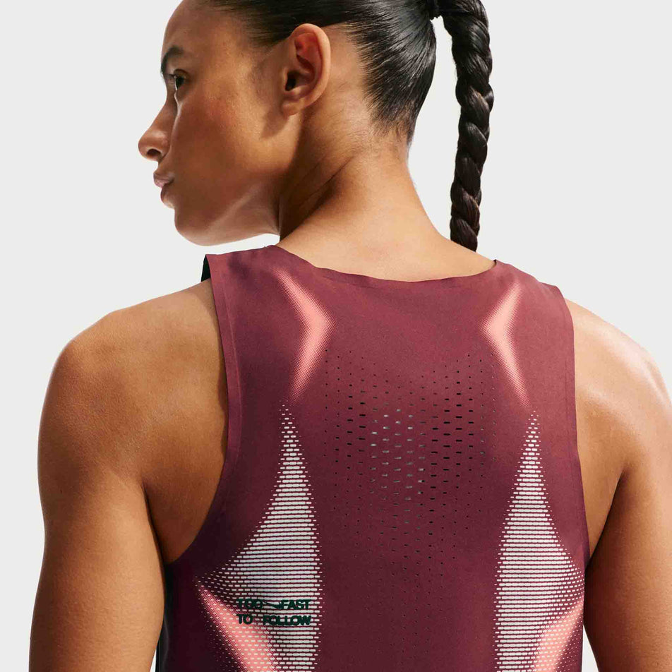 Back view of a model wearing the Nike Women's AeroSwift Dri-FIT ADV Cropped Running Tank Top in the Team Red/Black/Black colourway.