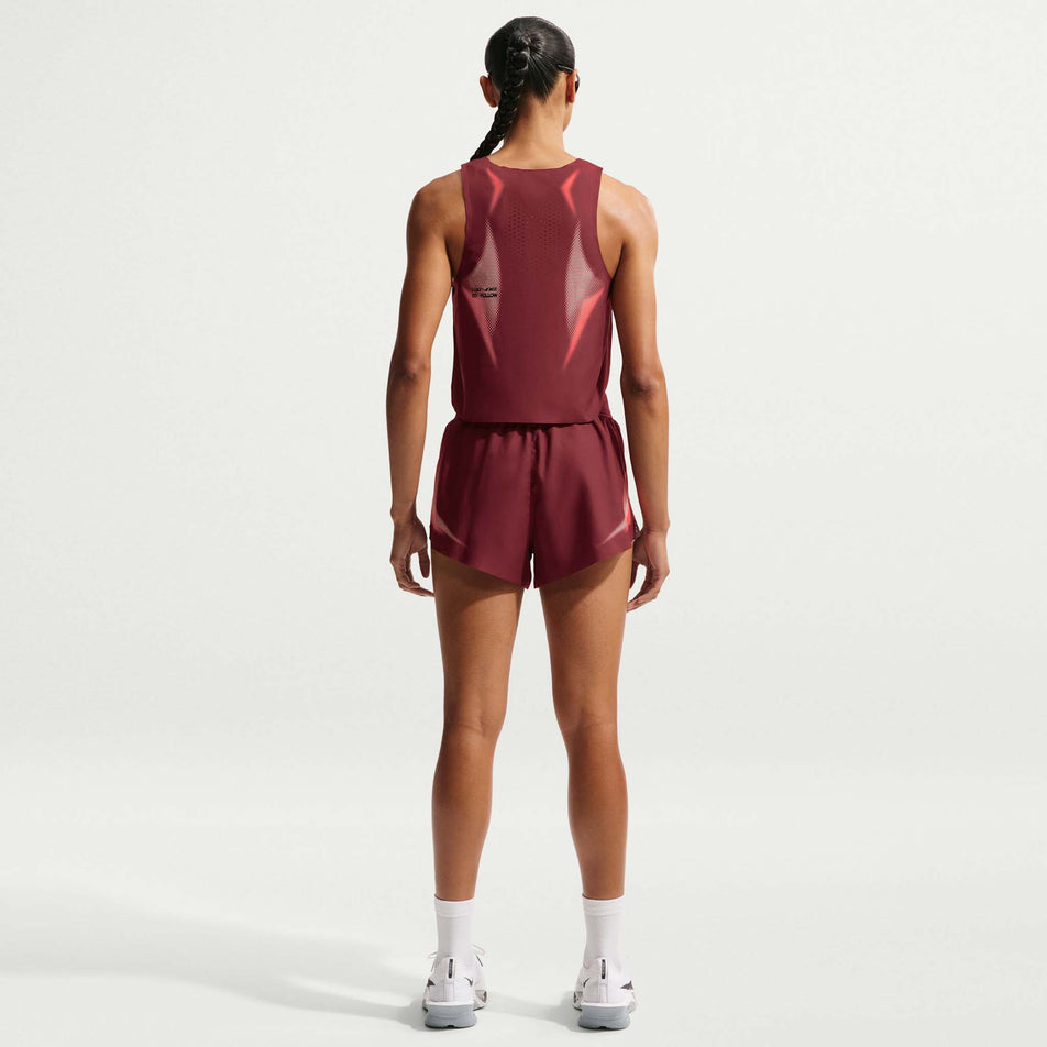 Back view of a model wearing the Nike Women's AeroSwift Dri-FIT ADV Cropped Running Tank Top in the Team Red/Black/Black colourway.