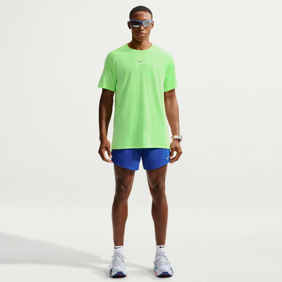 Front view of a model wearing the Nike Men's Stride Aero-FIT Short-Sleeve Running Top in the Volt/Light Silver/Reflective Silvern colourway.