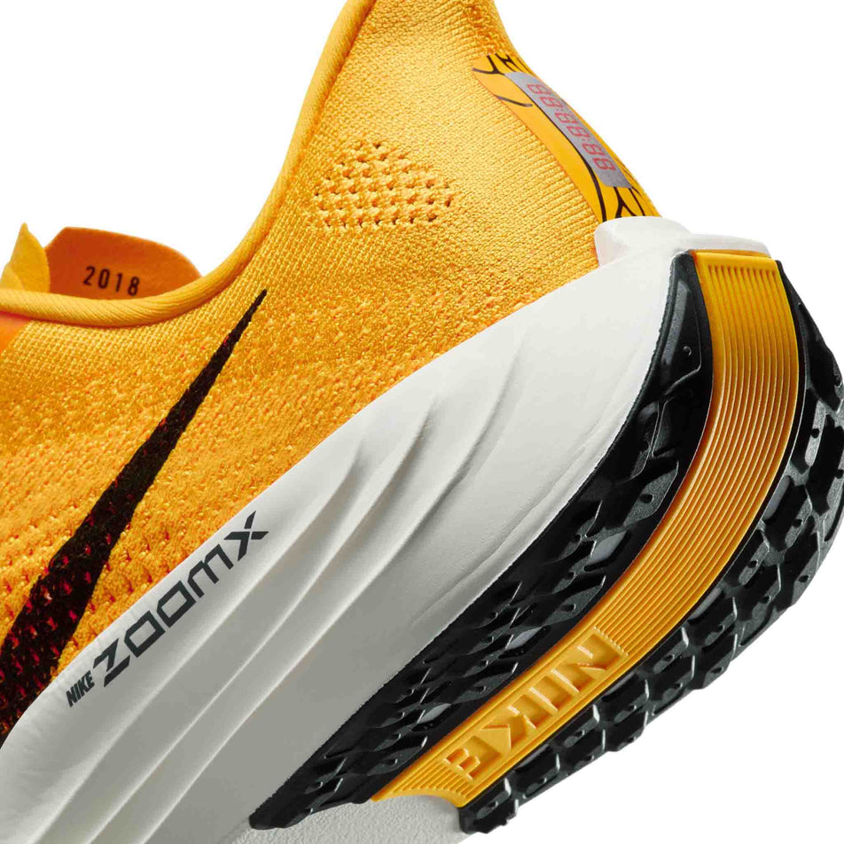 Close up of the midsole of the left shoe from a pair of Nike Men's Pegasus Plus LV8 Road Running Shoes in the University Gold/Black-Laser Orange Sail colourway. (8684355584162)