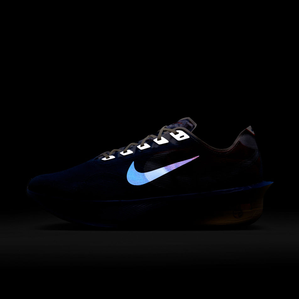 The reflective Nike Swoosh and reflective graphics on the lateral side of the left shoe from a pair of Nike Men's Vaporfly 4 Premium Road Racing Shoes in the Multi-Color/Clear-Mountain Blue-Fire Red colourway. (8723630260386)