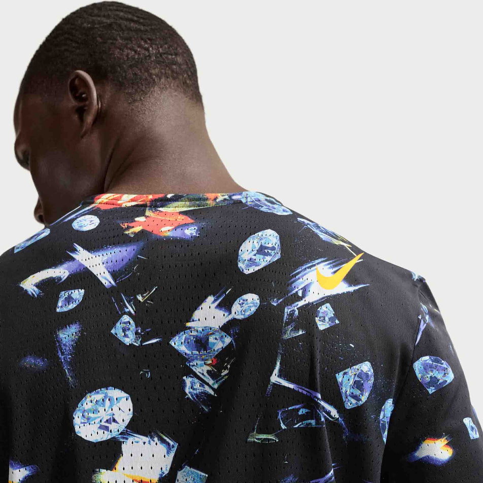 Back view of a model wearing the Nike Men's AeroSwift Dri-FIT ADV Short-Sleeve Running Top in the Black/Laser Orange colourway.