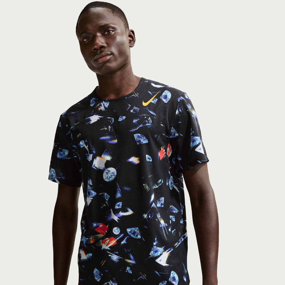 Front view of a model wearing the Nike Men's AeroSwift Dri-FIT ADV Short-Sleeve Running Top in the Black/Laser Orange colourway.