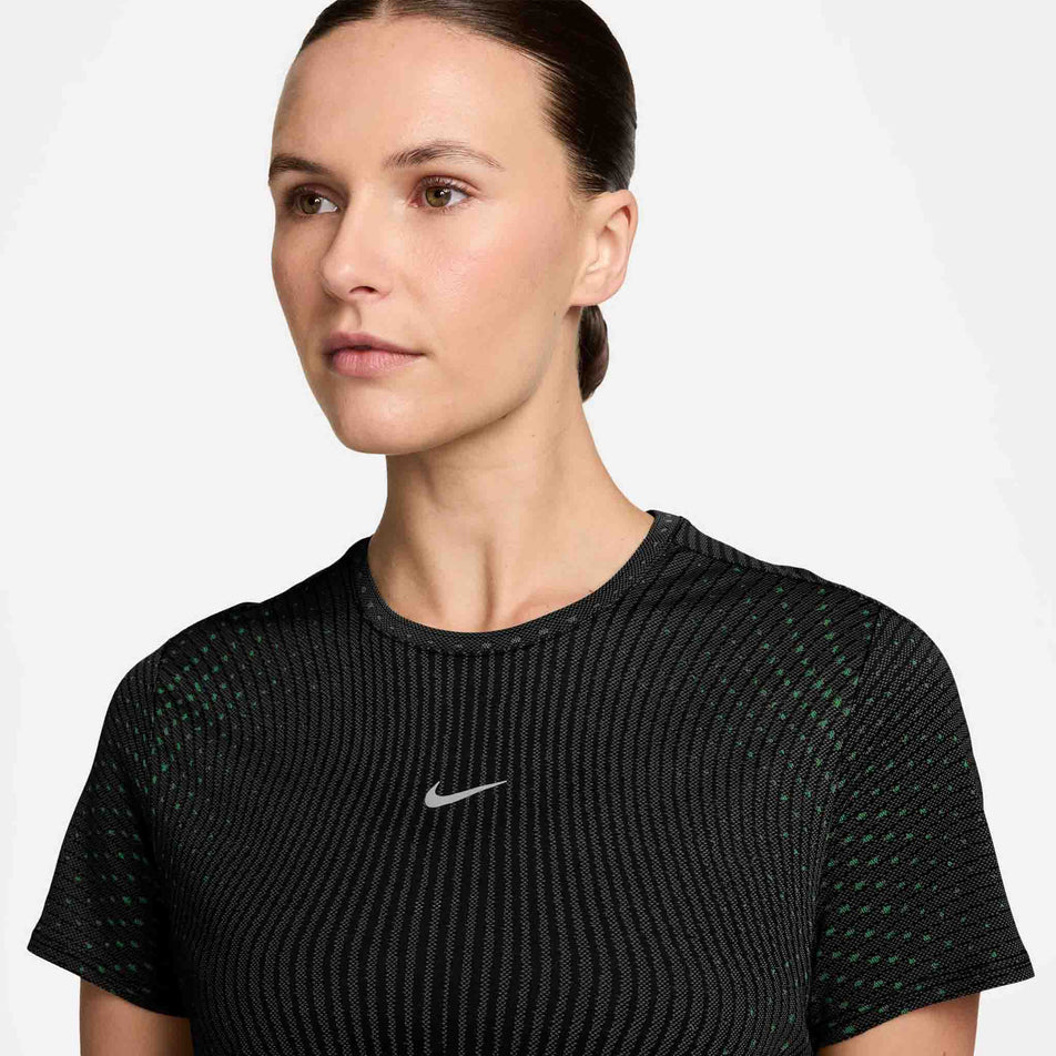 Front view of a model wearing the Nike Women's Swift Aero-FIT Short-Sleeve Running Top in the Black/Green colourway.