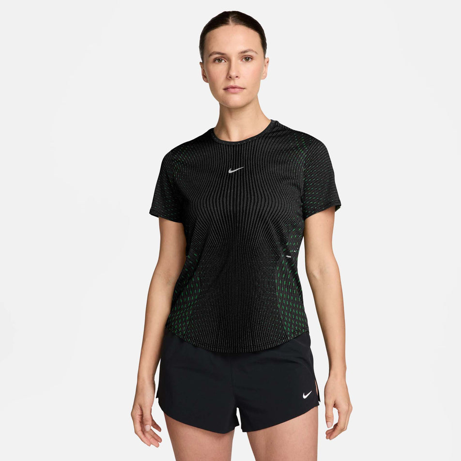 Front view of a model wearing the Nike Women's Swift Aero-FIT Short-Sleeve Running Top in the Black/Green colourway.