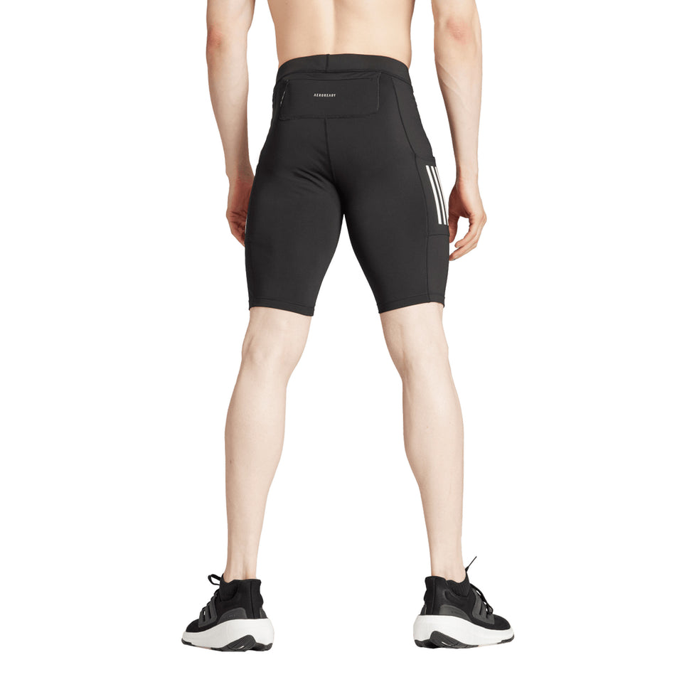 Back view of a model wearing the adidas Men's Own The Run Short Tights in the Black colourway. (8751020671138)