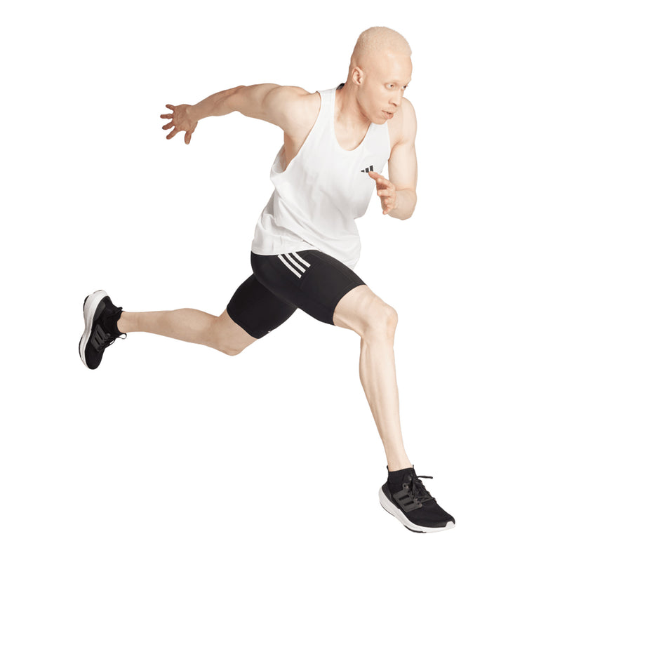 Angled view of a model wearing the adidas Men's Own The Run Short Tights in the Black colourway. (8751020671138)