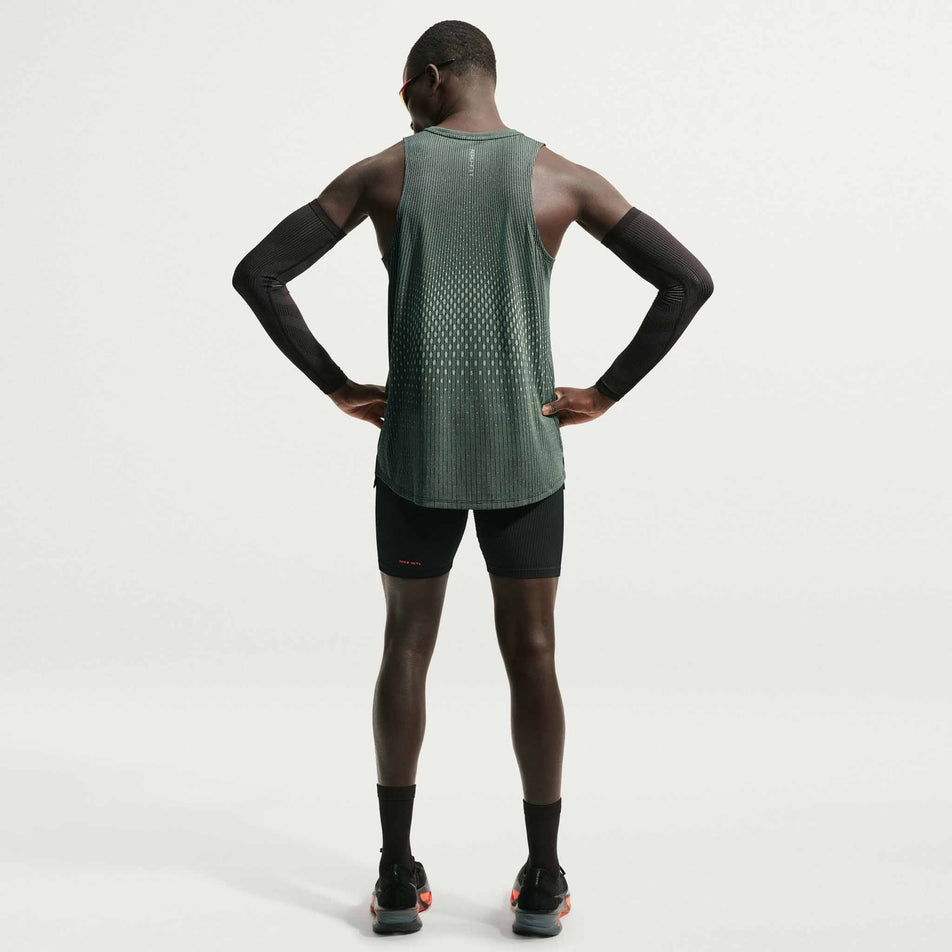 Back view of a model wearing the Nike Men's Stride Aero-FIT Running Tank Top in the Black/Light Green Spark/Reflective Silver colourway.
