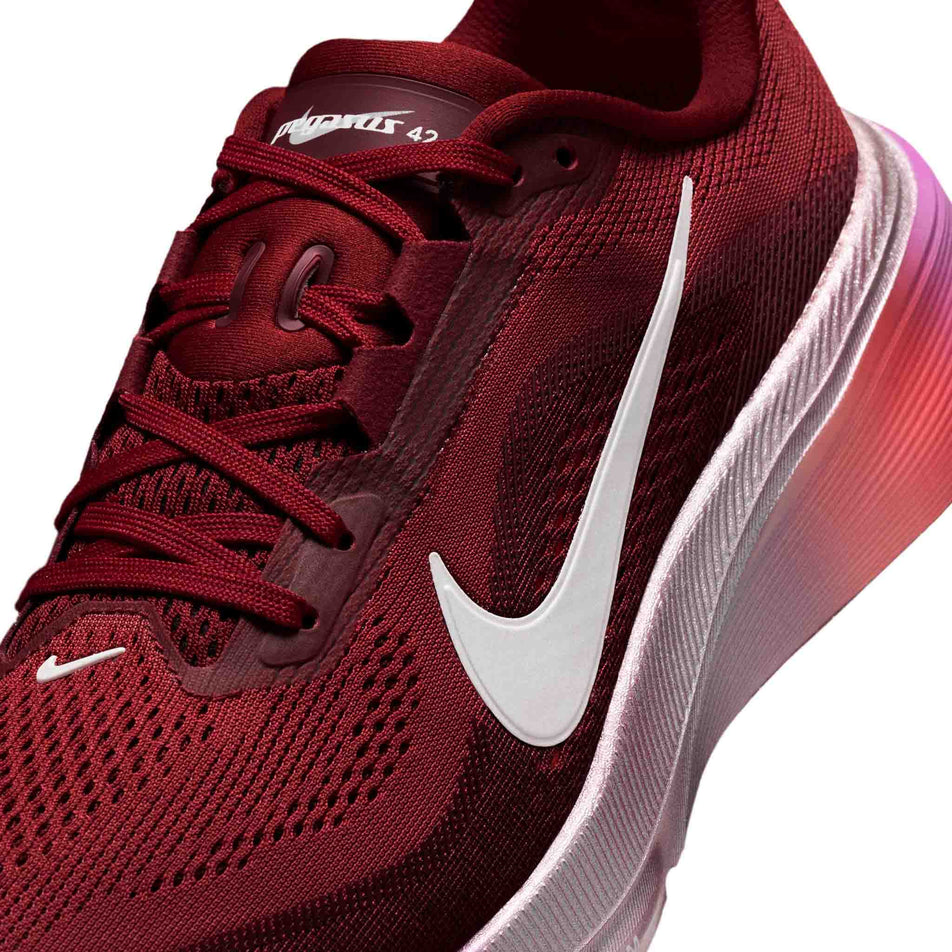Close-up view of the upper of the left shoe from a pair of Nike Women's Pegasus 42 SE Road Running Shoes in the Team Red/Barely Green-Atomic Pink colourway.