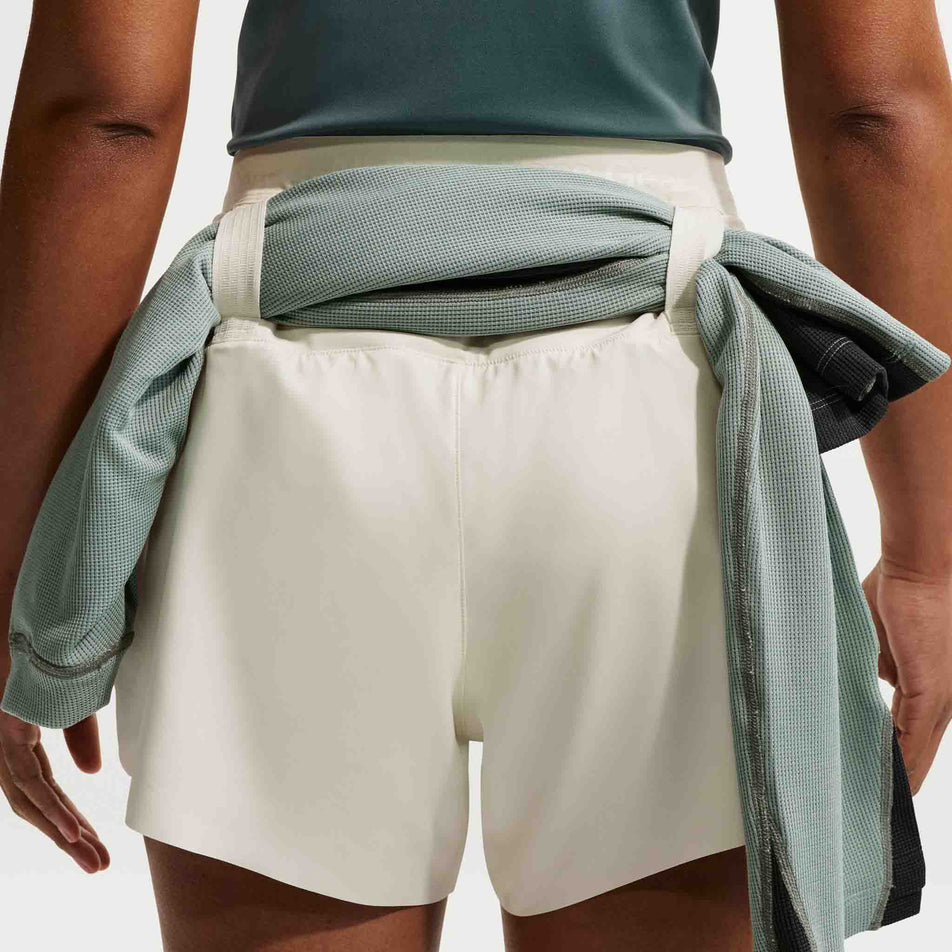 A top stowed in the loops on the back of the Nike Women's ACG Dri-FIT Mid-Rise Brief-Lined Trail Running Shorts in the Sea Glass/Sea Glass/Summit White colourway.