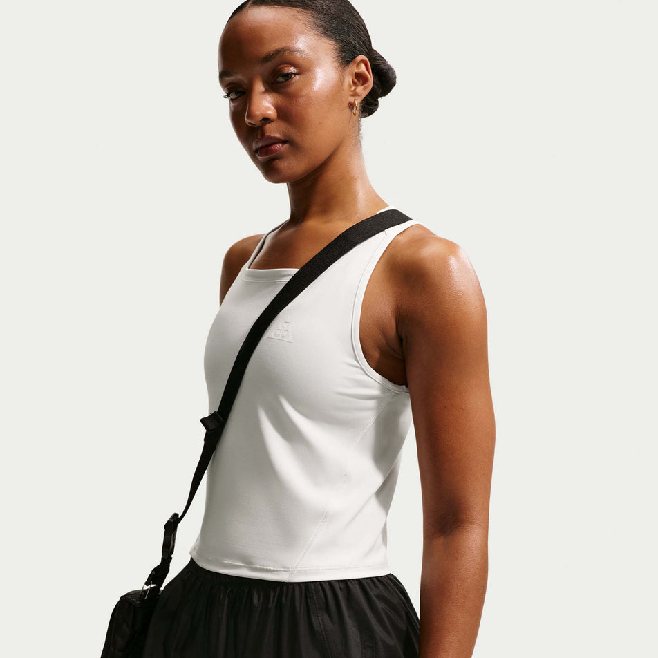 Angled view of a model wearing the Nike Women's ACG Dri-FIT Trail Running Tank Top in the Phantom/Photon Dust/Summit White colourway.