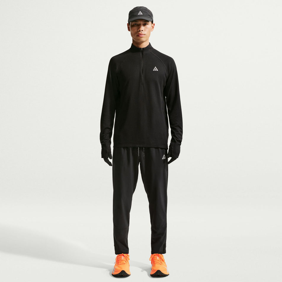 Front view of a model wearing the Nike Men's ACG Dri-FIT Mid-Layer 1/4-Zip Trail Running Top in the Black/Black/Summit White colourway.