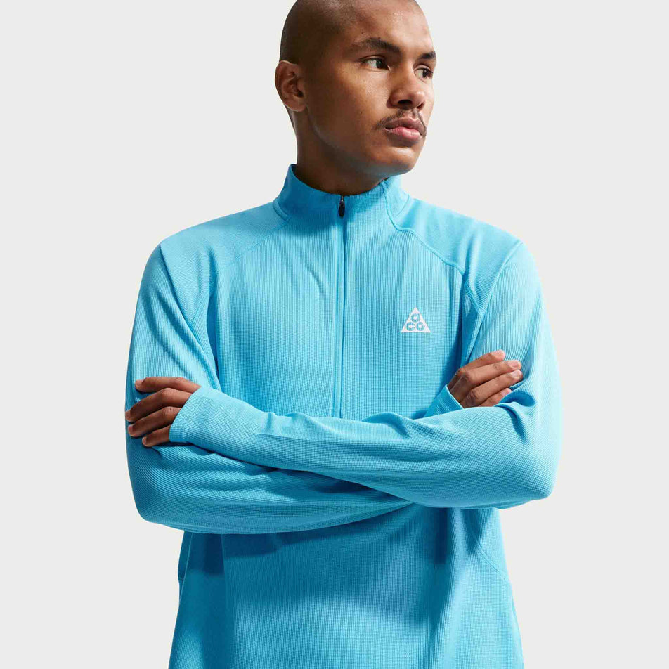 Front view of a model wearing the Nike Men's ACG Dri-FIT Mid-Layer 1/4-Zip Trail Running Top in the Baltic Blue/Baltic Blue/Summit White colourway.