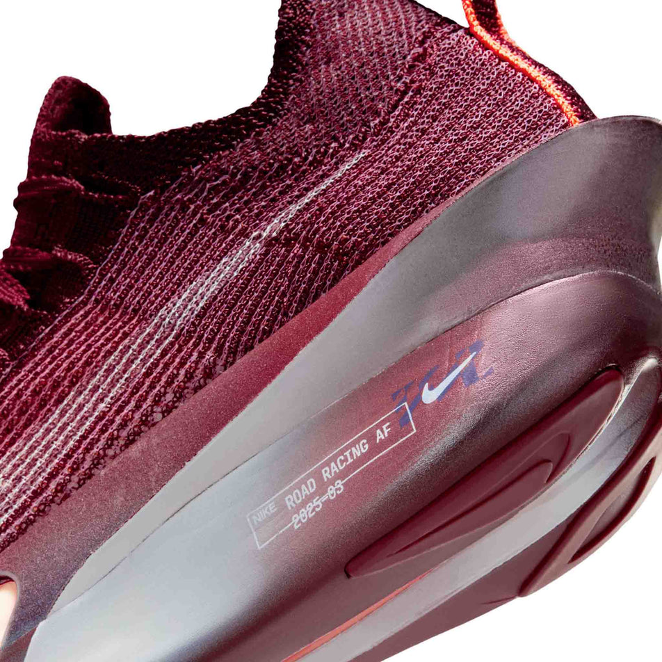 Close-up view of the rearfoot section of the left shoe from a pair of Nike Women's Alphafly 3 Road Racing Shoes in the Team Red/Barely Green-Bright Crimson colourway.