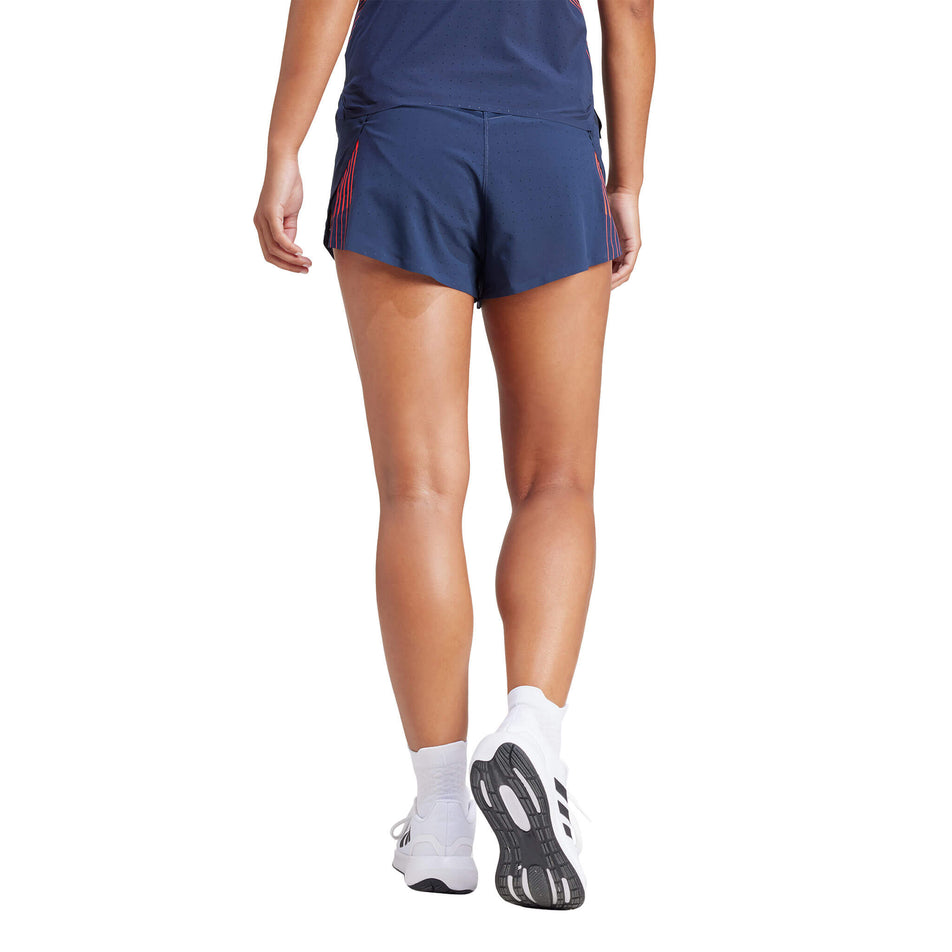 Back view of a model wearing a pair of adidas Women's Team GB Adizero Running Split Shorts in the Legend Ink colourway. Model is also wearing a top, socks and shoes. (8323635052706)