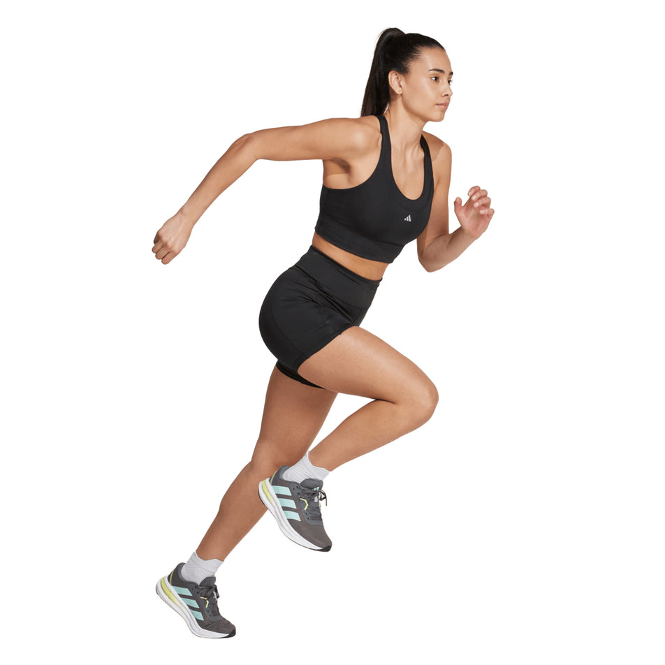 Angled view of a model wearing the adidas Women's Own The Run Short Leggings in the Black colourway. (8665248268450)