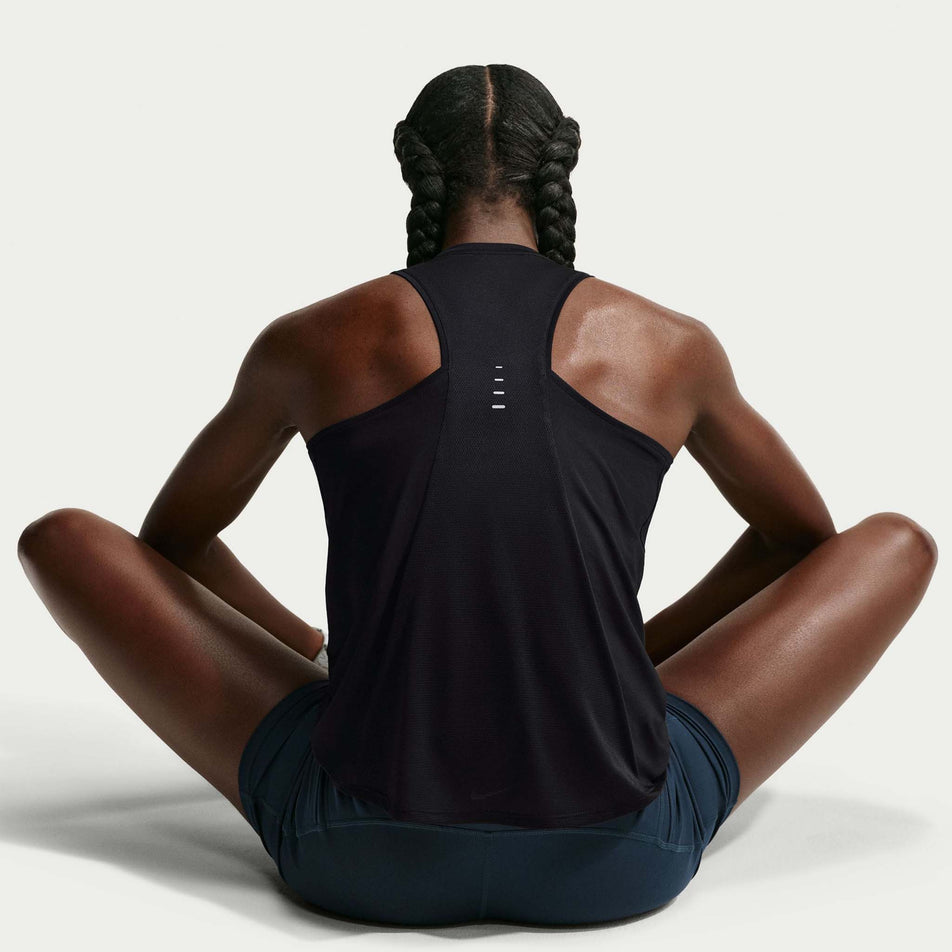 Back view of a model wearing the Nike Women's Swift Dri-FIT Running Tank Top in the Black/Reflective Silver colourway.