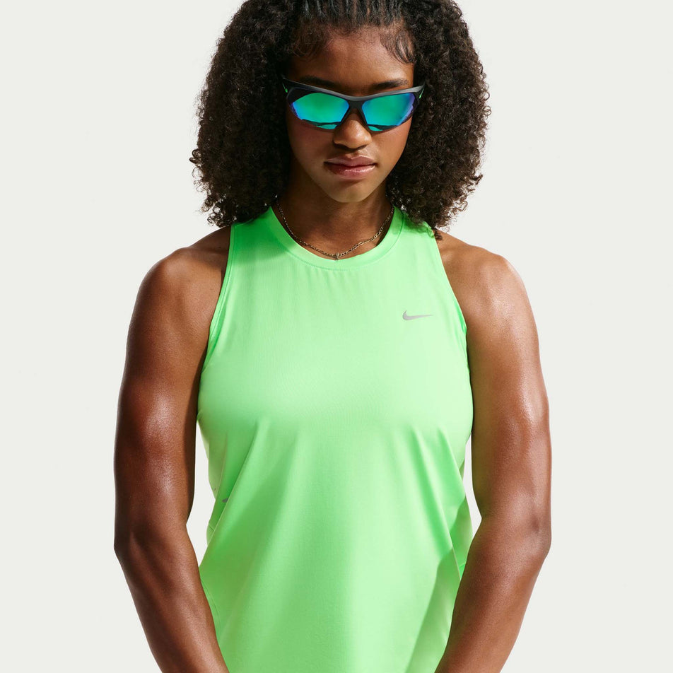 Front view of a model wearing the Nike Women's Swift Dri-FIT Running Tank Top in the Illusion Green/Reflective Silver colourway.