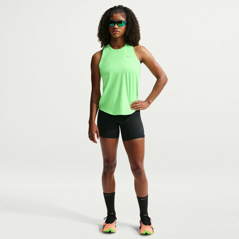Front view of a model wearing the Nike Women's Swift Dri-FIT Running Tank Top in the Illusion Green/Reflective Silver colourway.
