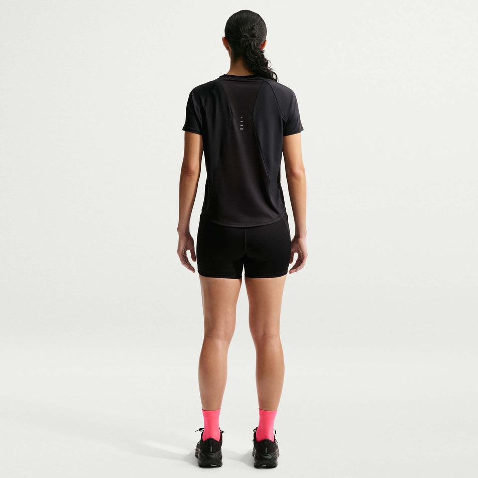 Back view of a model wearing the Nike Women's Swift Dri-FIT Short-Sleeve Running Top in the Black/Reflective Silver colourway.