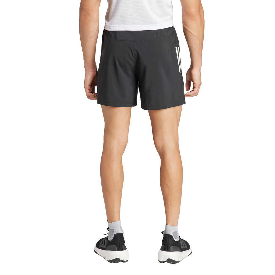 Back view of a model wearing the adidas Men's Own The Run Base Short in the Black colourway. (8567004004514)