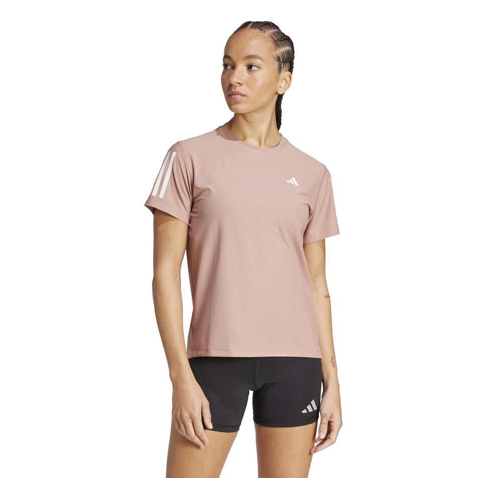 Front view of a model wearing the adidas Women's Own The Run Base Tee in the Warm Clay colourway. (8567456235682)