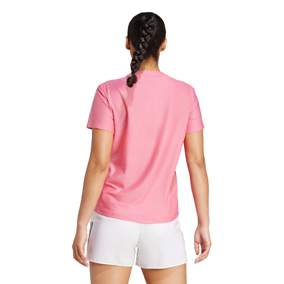 Back view of a model wearing the adidas Women's Own The Run Base Tee in the Pink Fusion colourway. (8567025172642)