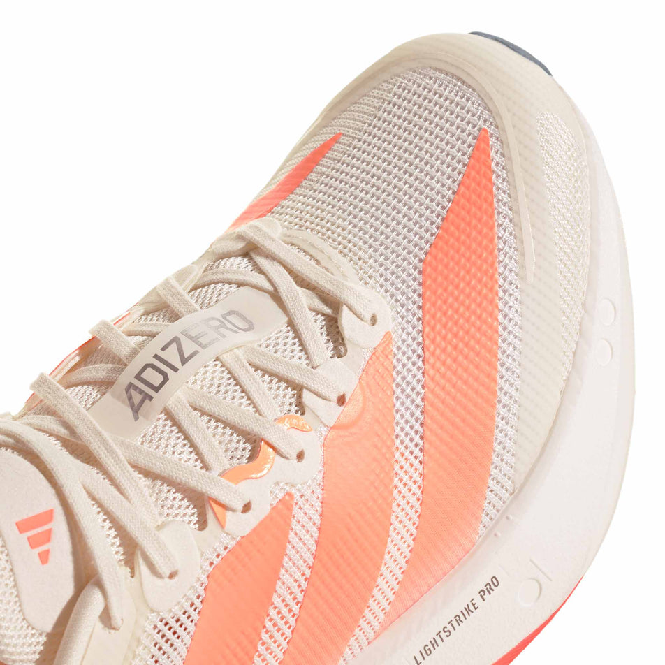 Close-up view of the toebox of the right shoe from a pair of adidas Women's Adizero Boston 13 Running Shoes in the Off White/Beam Orange/Acid Orange colourway.