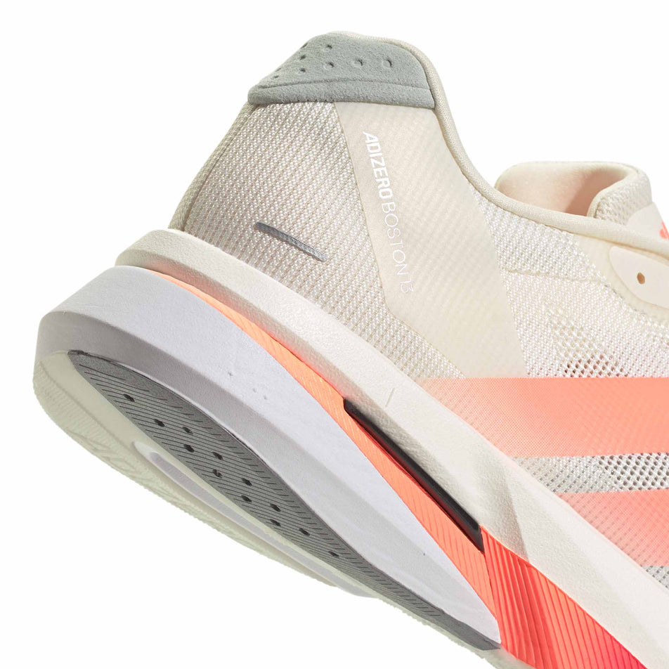 Close-up view of the rearfoot section of the right shoe from a pair of adidas Men's Adizero Boston 13 Running Shoes in the Off White/Lucid Orange/Grey colourway.