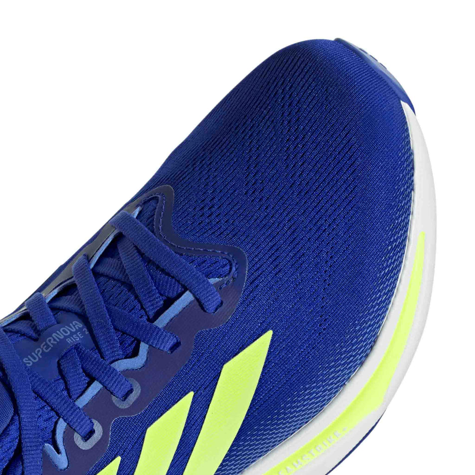 Close up of the toebox of the right shoe from a pair of adidas Men's Supernova Rise 2 Running Shoes in the Lucid Blue/Hi-Red Yellow/Blue Fusion colourway. (8662545006754)