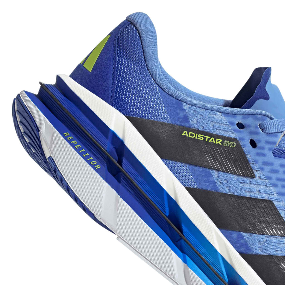 Close up of the heel section of the right shoe from a pair of adidas Men's Adistar BYD Running Shoes in the Blue Fusion/Legend Ink/Solar Slime colourway. (8662536290466)