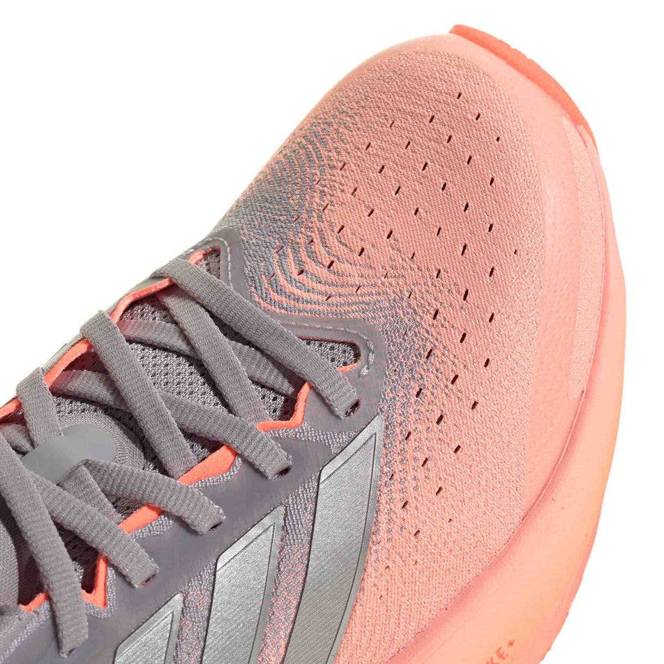 Close-up view of the toebox of the right shoe from a pair of adidas Women's Supernova Rise 3 Running Shoes in the Clear Orange/Silver met./Glory Grey colourway.