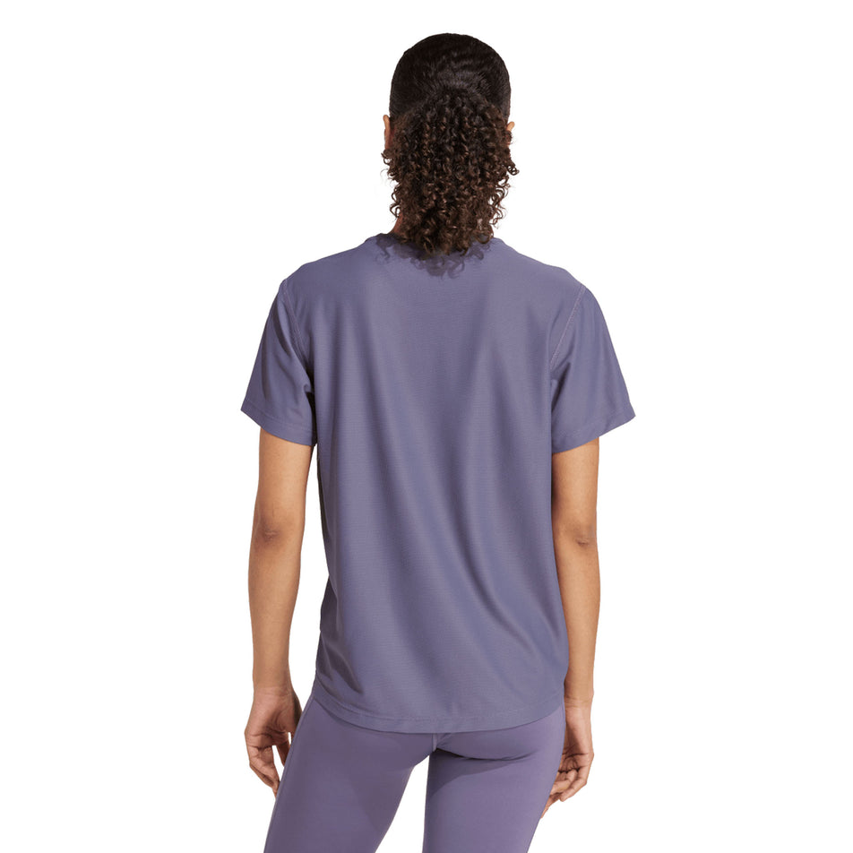 Back view of a model wearing the adidas Women's Own The Run Base Tee in the Preloved Violet colourway. (8665231327394)