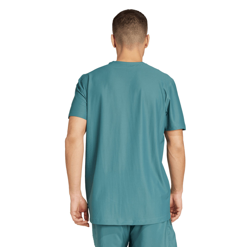 Back view of a model wearing the adidas Men's Own The Run Base Tee in the Preloved Teal colourway. (8663053500578)