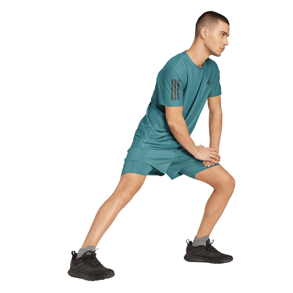 Front view of a model wearing the adidas Men's Own The Run Base Tee in the Preloved Teal colourway. (8663053500578)