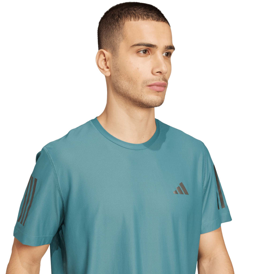 Front view of a model wearing the adidas Men's Own The Run Base Tee in the Preloved Teal colourway. (8663053500578)