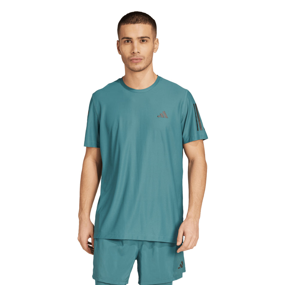 Front view of a model wearing the adidas Men's Own The Run Base Tee in the Preloved Teal colourway. (8663053500578)