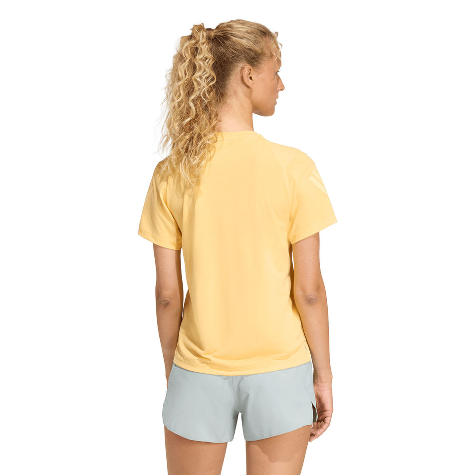 Back view of a model wearing the adidas Women's adi365 Tee in the Semi Ice Tangerine colourway.