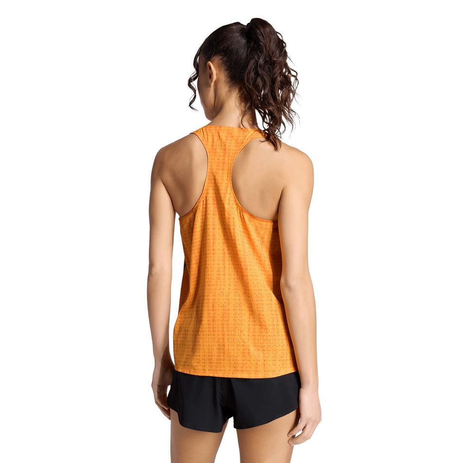 Back view of a model wearing the adidas Women's Adizero Singlet in the Pure Tangerine/Pure Orange colourway.