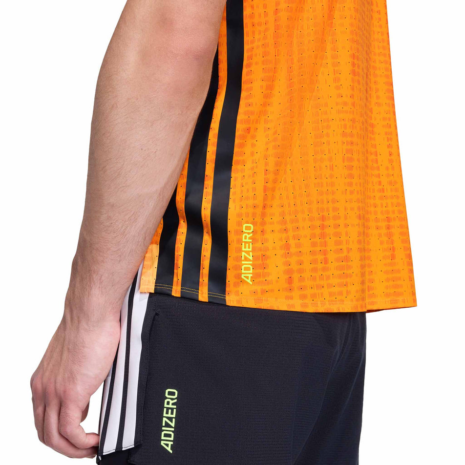 Angled view of a model wearing the adidas Men's Adizero Singlet in the Pure Tangerine/Pure Orange colourway.