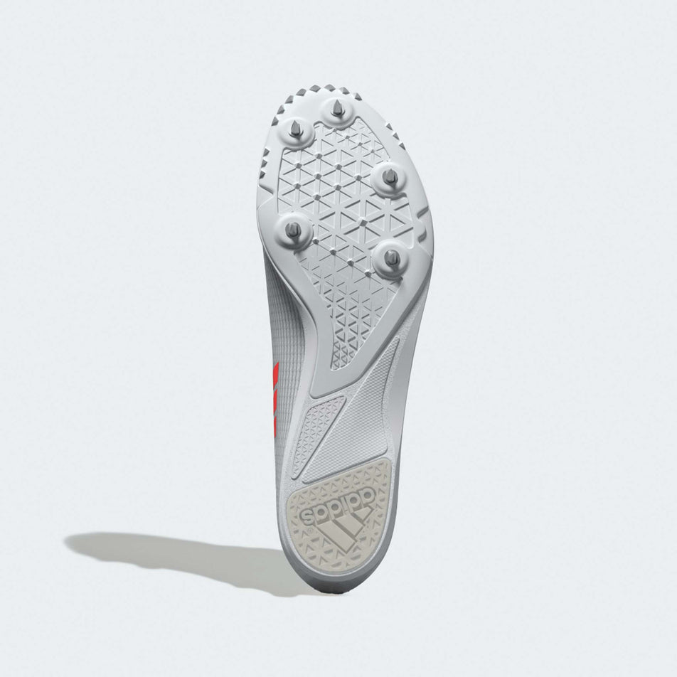 The outsole of the left shoe from a pair of adidas Junior-Unisex Allroundstar Running Spikes in the Ftwr White/Solar Turbo/Gold Met. colourway.