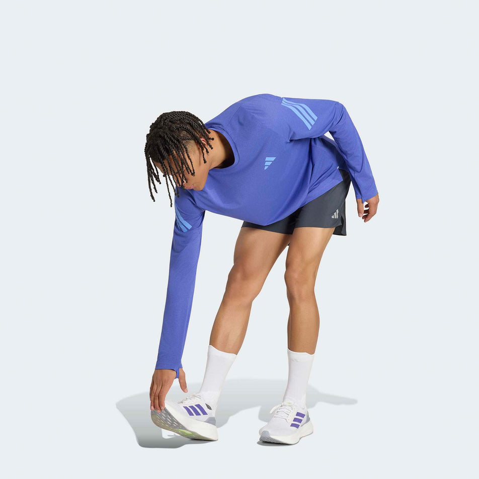 Angled view of a model wearing the adidas Men's adi365 Long Sleeve Running Top in the Dual Indigo. colourway.