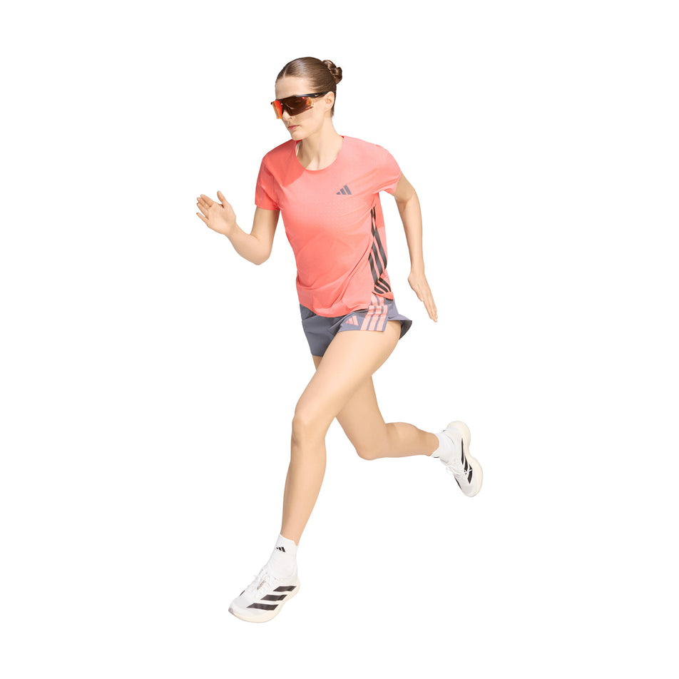 Angled view of a model wearing the adidas Women's Adizero Tee in the Semi Turbo colourway.
